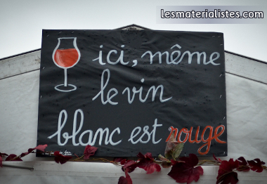 Pancarte "ici, même le vin blanc et rouge" sur un stand à la fête de l'humanité
